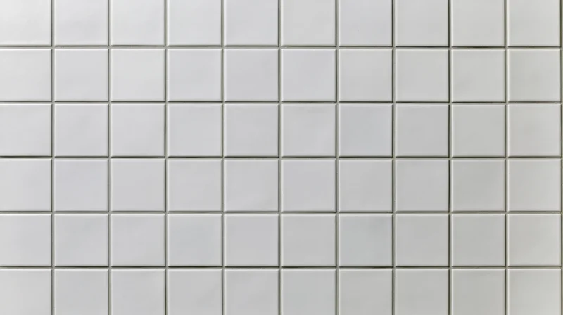 White ceramic square tiles arranged in a grid covering a wall
