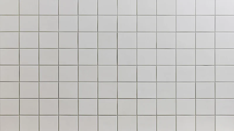 White ceramic square tiles arranged in a grid covering a wall