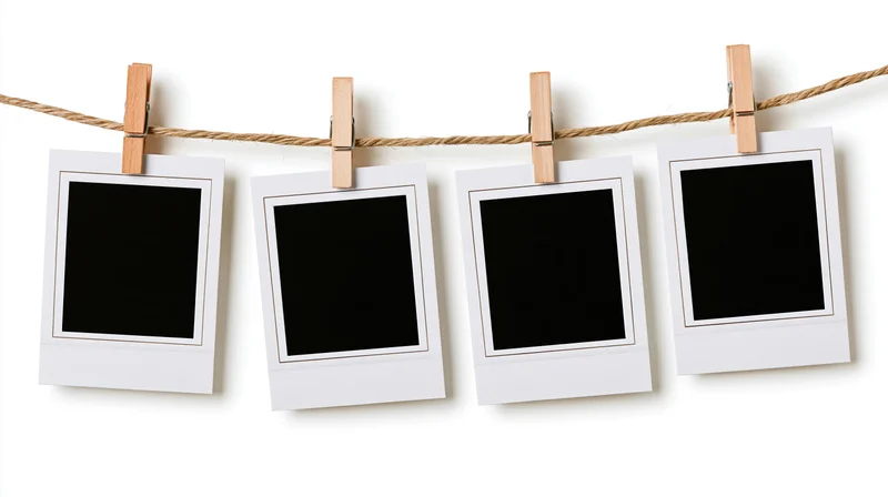 Four blank polaroid photo prints clipped to a twine cord against white background