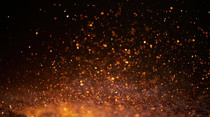 Glowing orange sparks rising from a dark surface against a black background