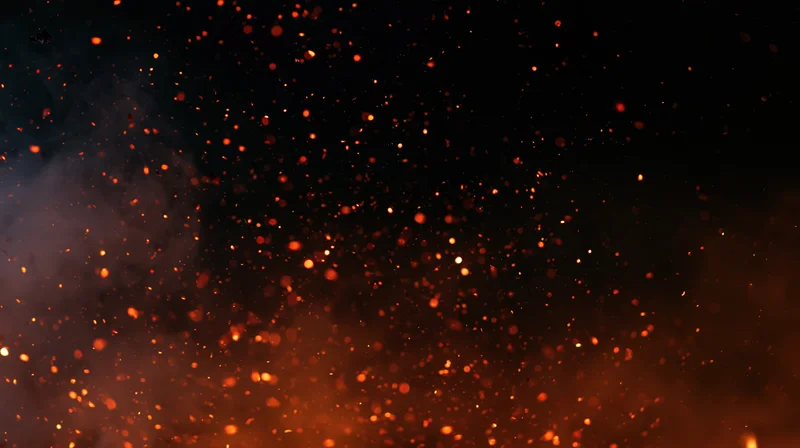 Glowing orange-red embers and sparks floating upward in dark night air with smoke