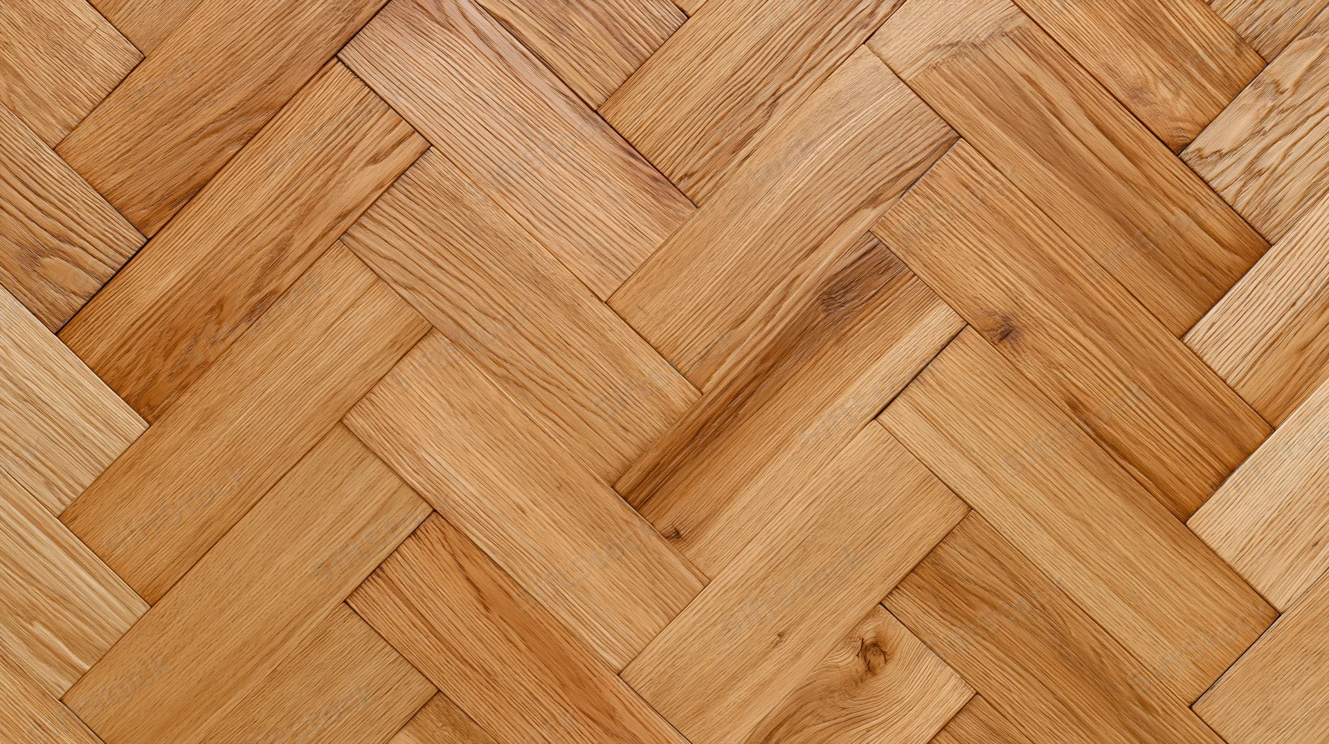 Herringbone patterned hardwood floor filling the frame with natural wood grain texture