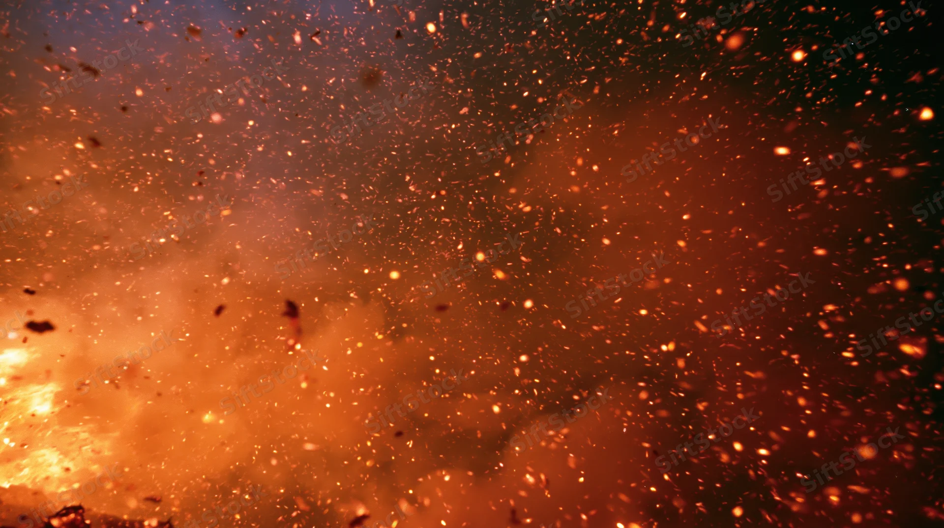 Glowing fire embers and sparks drifting upward in a fiery burst against a dark background