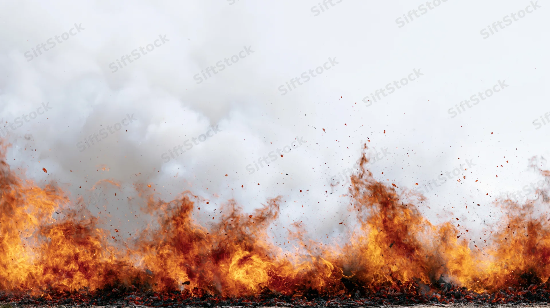 Intense flames burning along the ground with thick smoke rising above