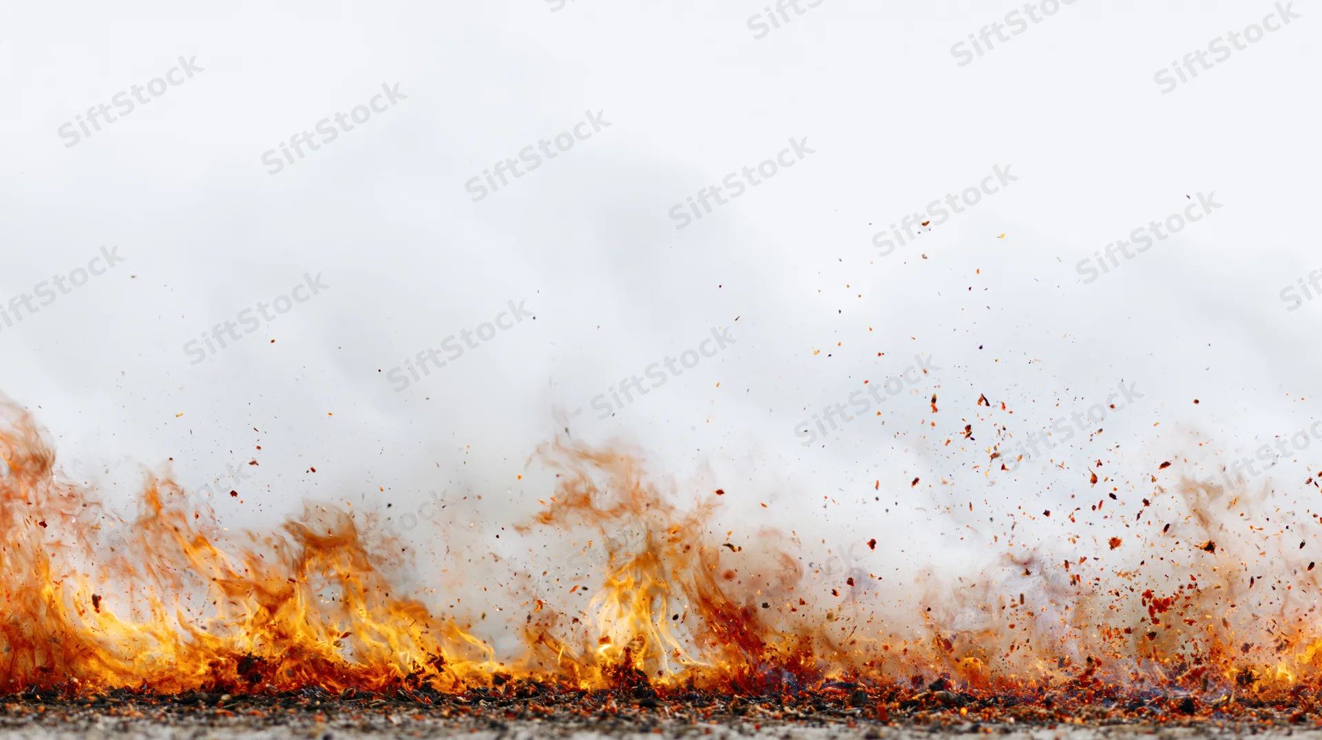 Intense fire flames burning along the bottom edge of the frame with smoke and sparks rising above asphalt surface