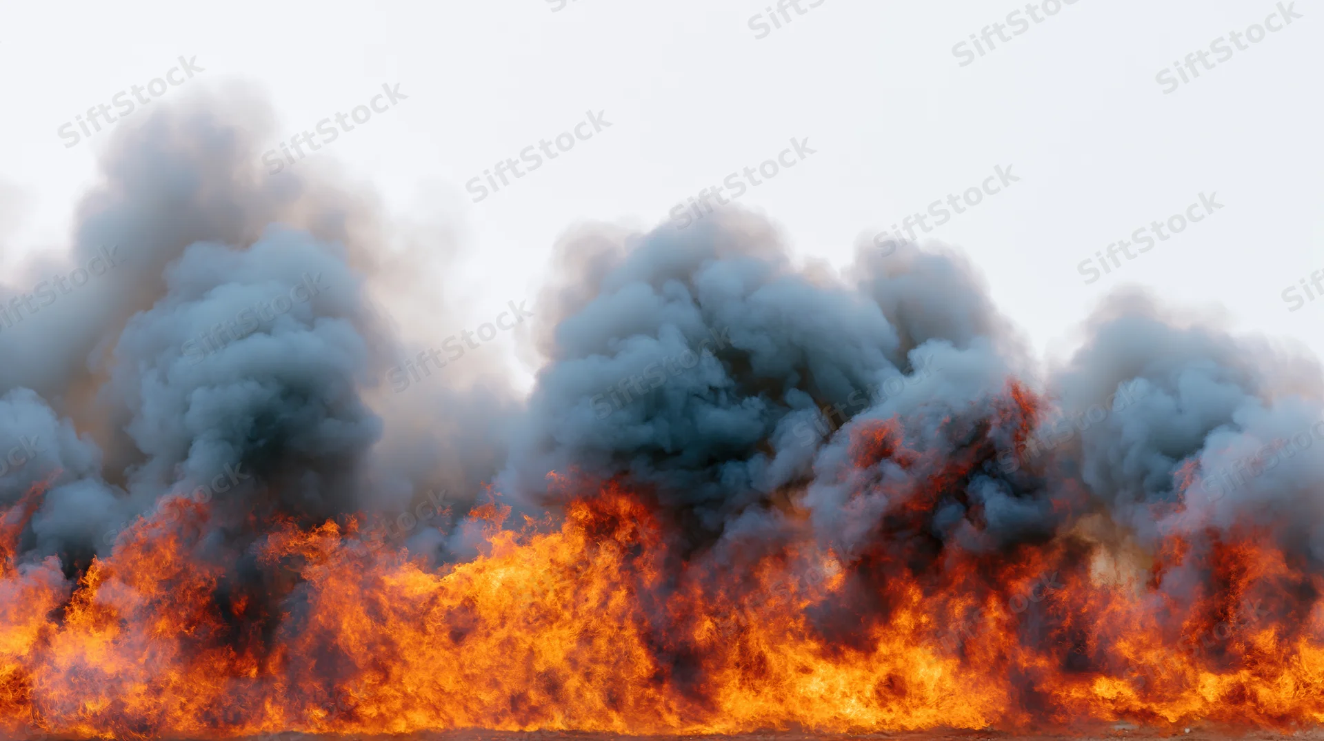 Intense flames burning across the horizon with thick smoke rising into the sky