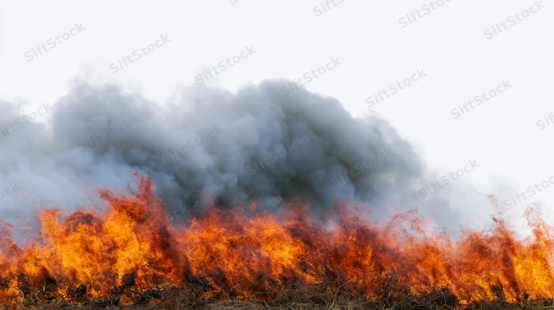 Intense fire burning across dry vegetation under a smoky sky