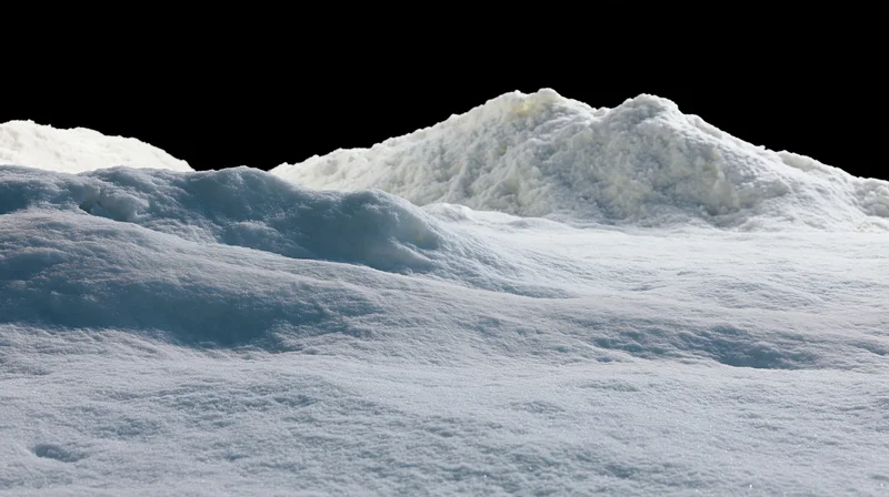 Snow-covered ground surface with gentle rises under dark sky