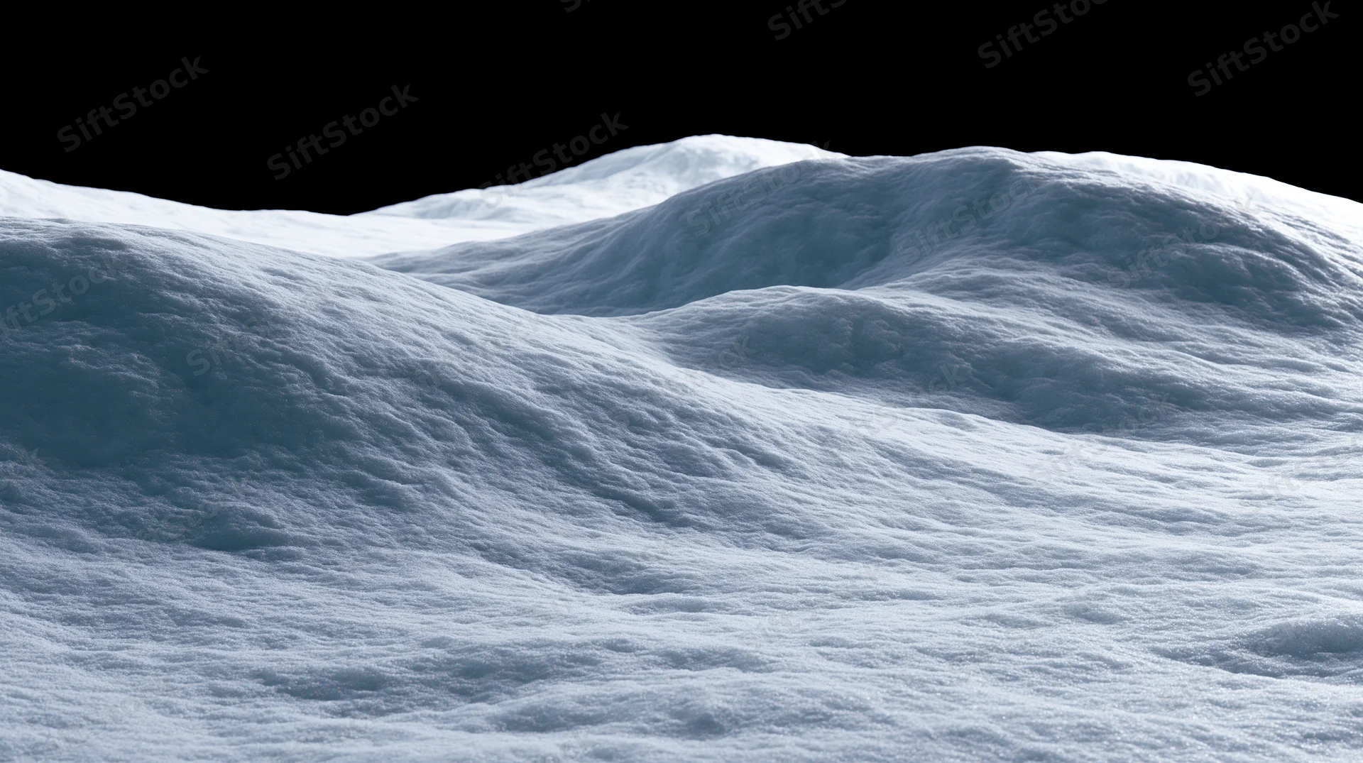 Snow-covered undulating terrain under dark sky
