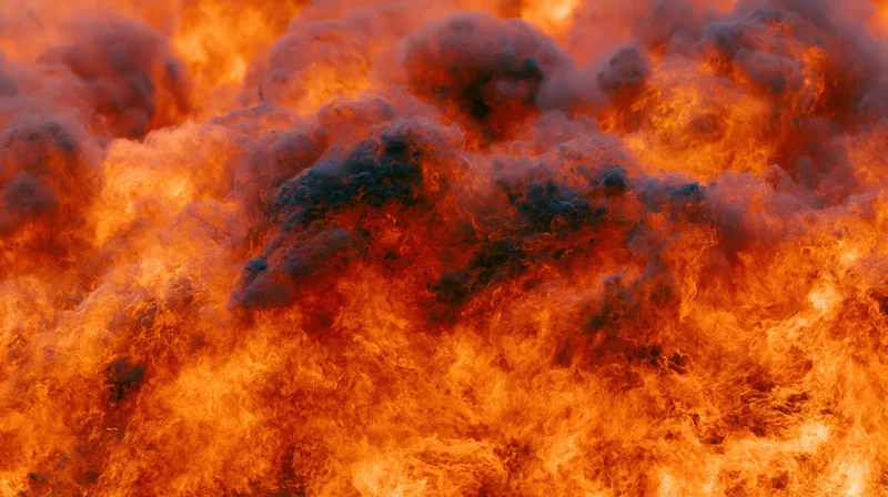 Massive wall of fire filling the frame in extreme close-up with swirling flames and dark smoke