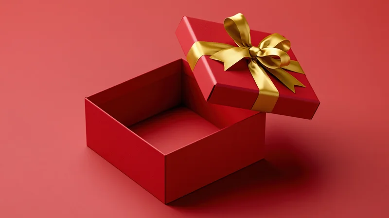 Open red gift box with gold ribbon and bow lid floating above on red surface