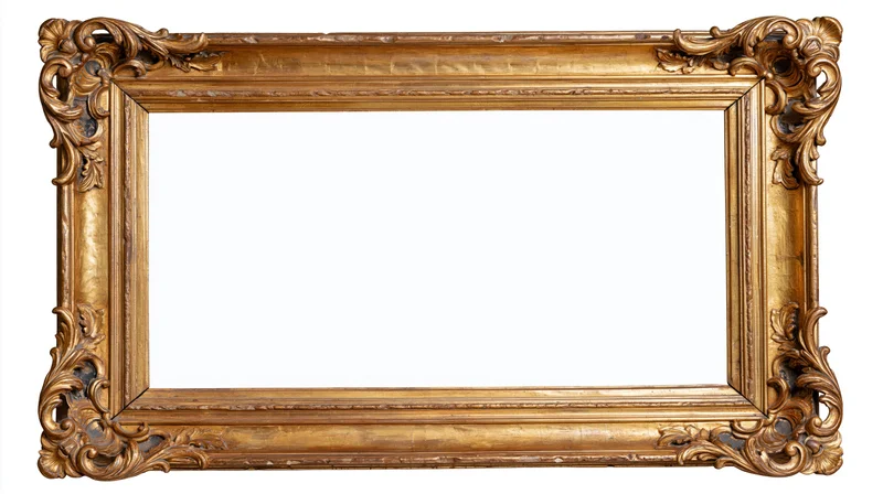 Ornate antique gold picture frame with baroque carved floral details isolated on white