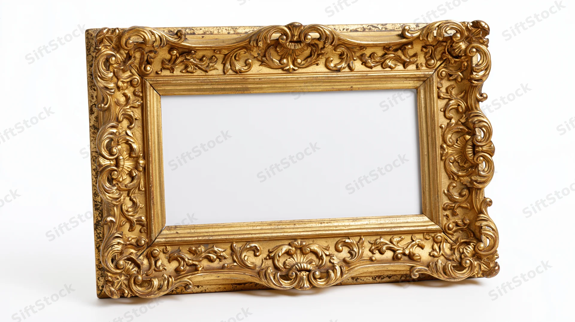 Ornate antique gold picture frame with baroque scrollwork standing on white background