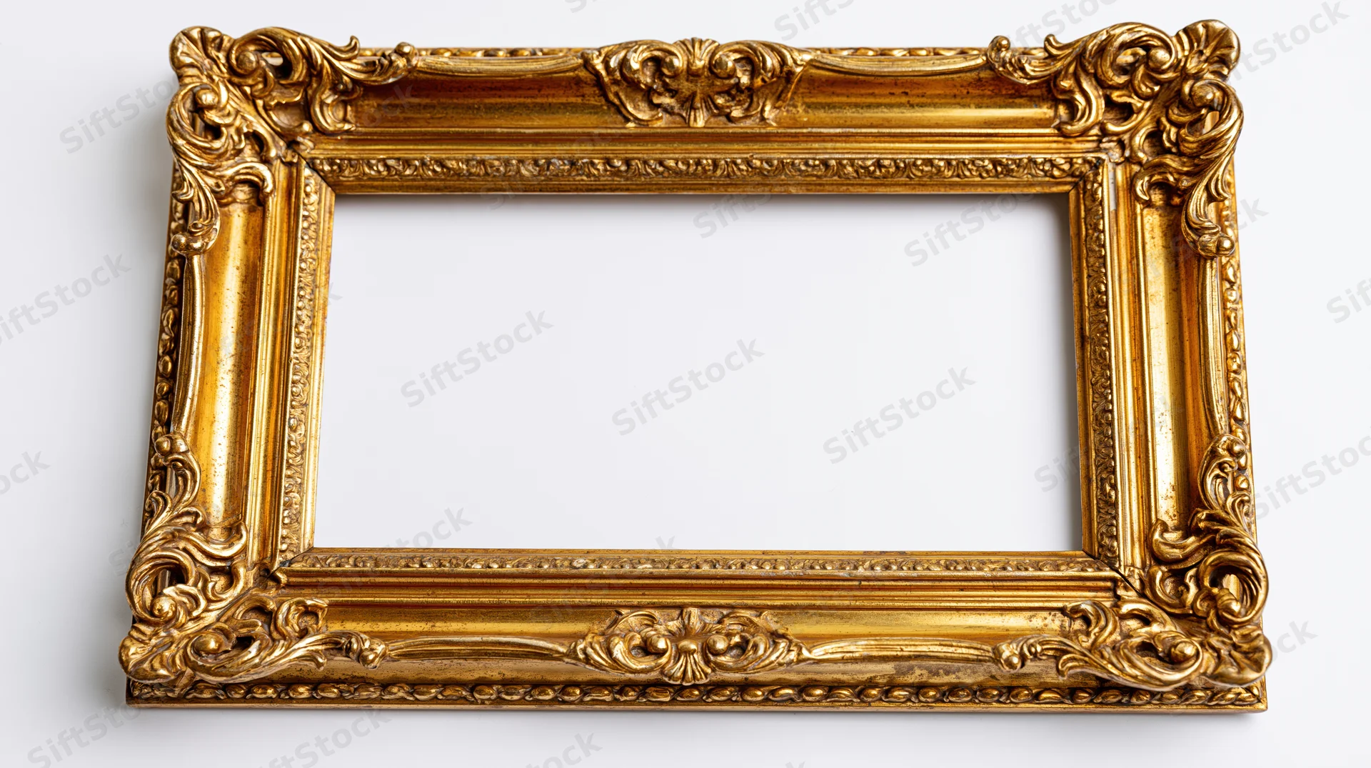 Ornate baroque gilt picture frame with carved scrollwork on white background