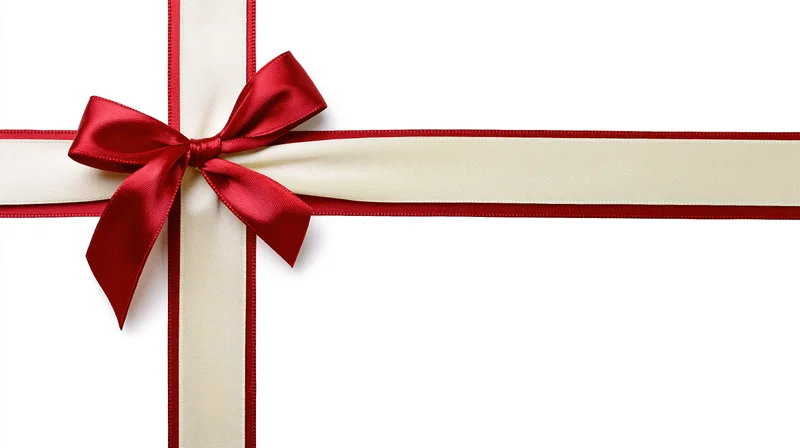 Red and cream satin ribbon tied in a bow crossing horizontally and vertically on white background