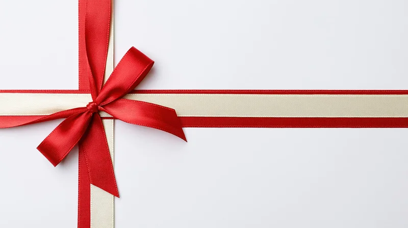 Red and cream satin ribbon tied in a bow crossing horizontally and vertically on a white background