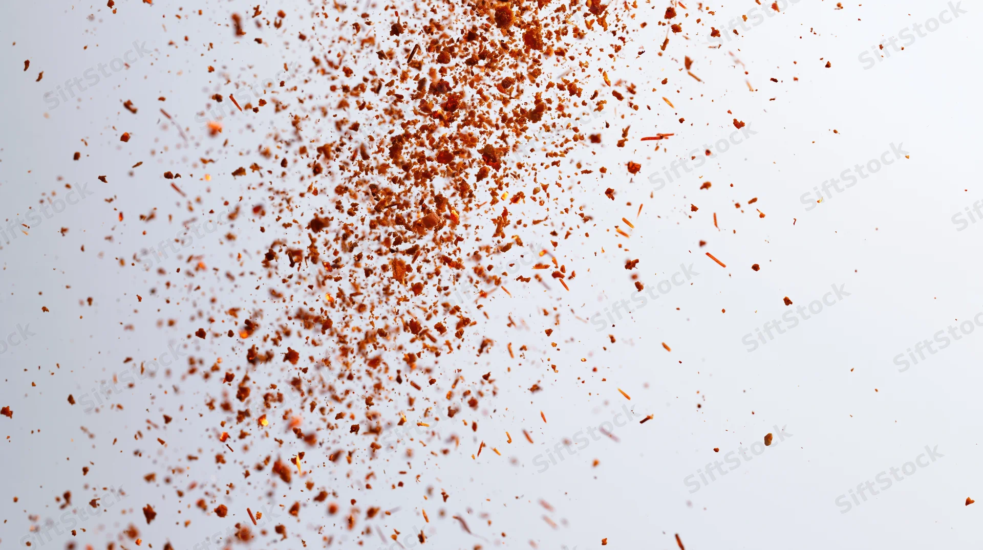 Orange fire embers and sparks floating midair against white background