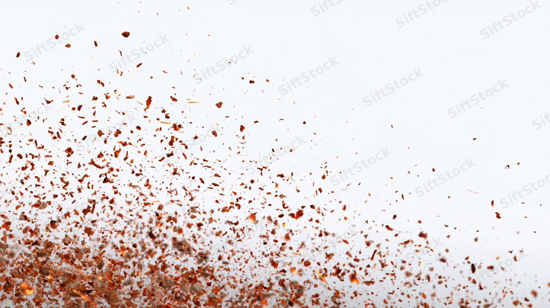 Orange fire embers and sparks floating mid-air against white background