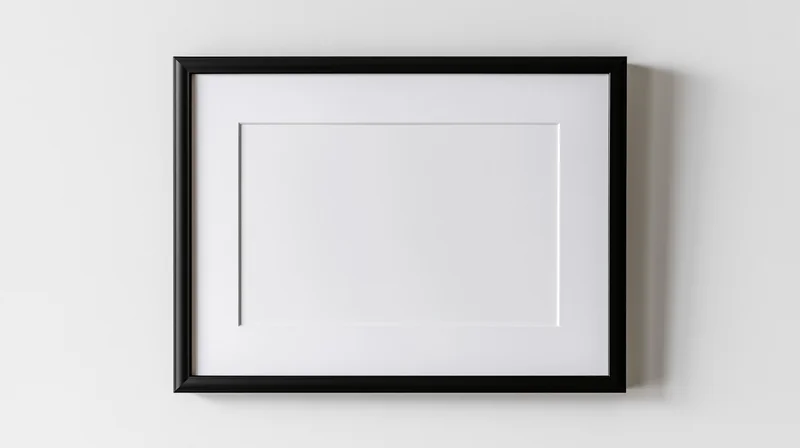 Black rectangular picture frame with white mat hanging on a plain white wall