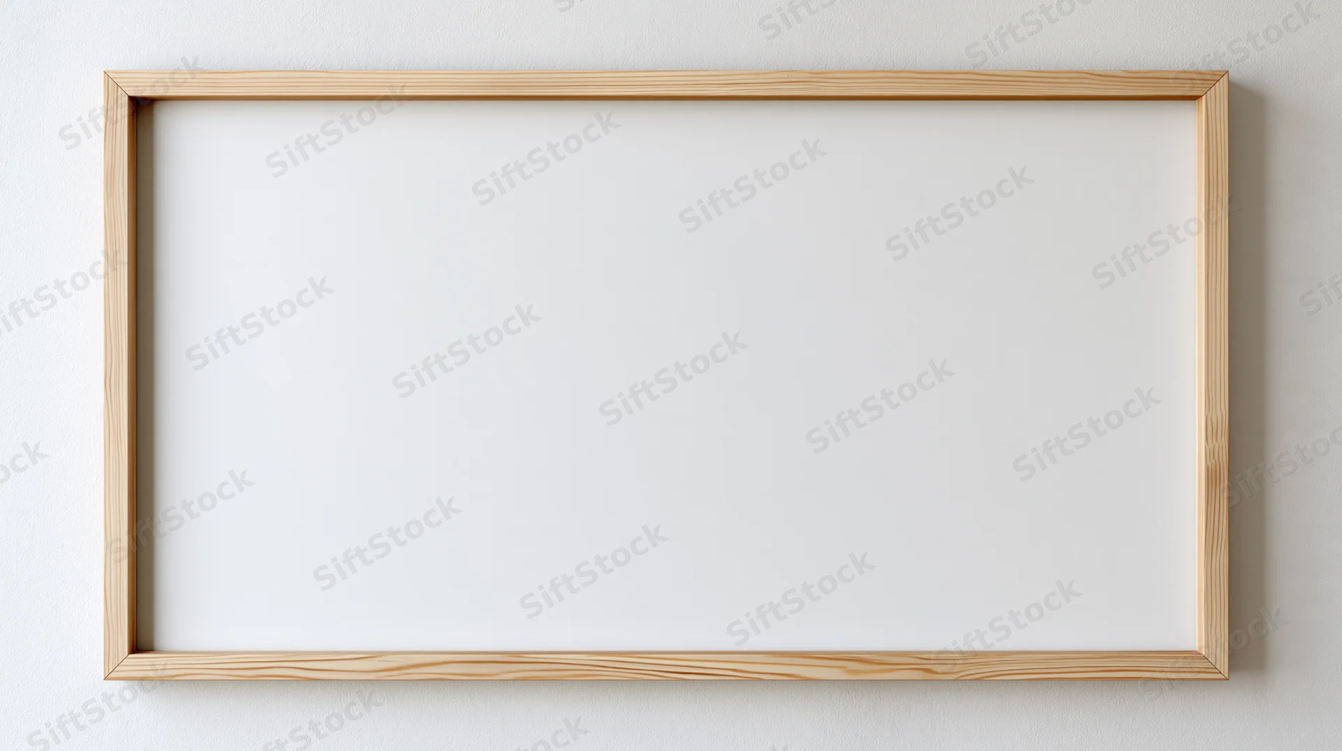 Thin natural wood picture frame hanging on plain white wall