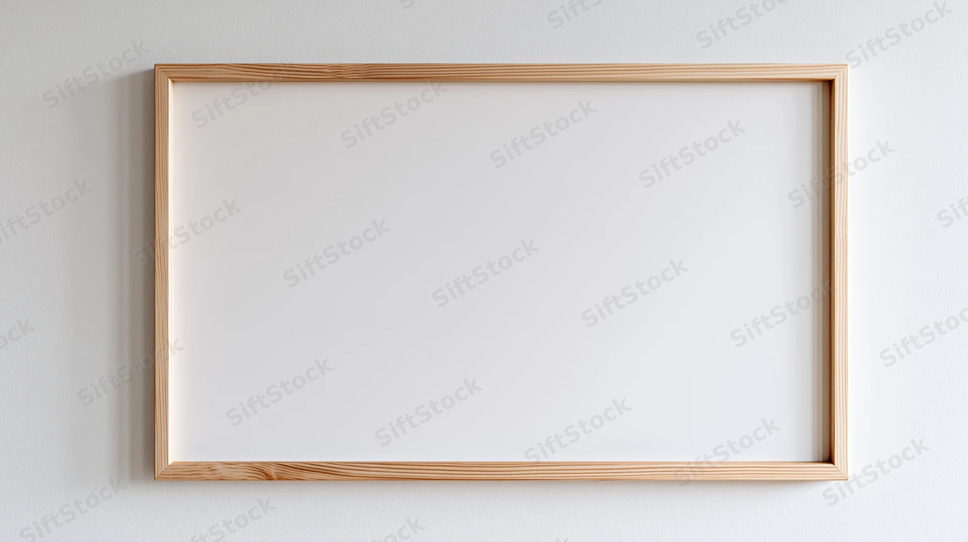 Thin natural wood picture frame hanging on plain white wall