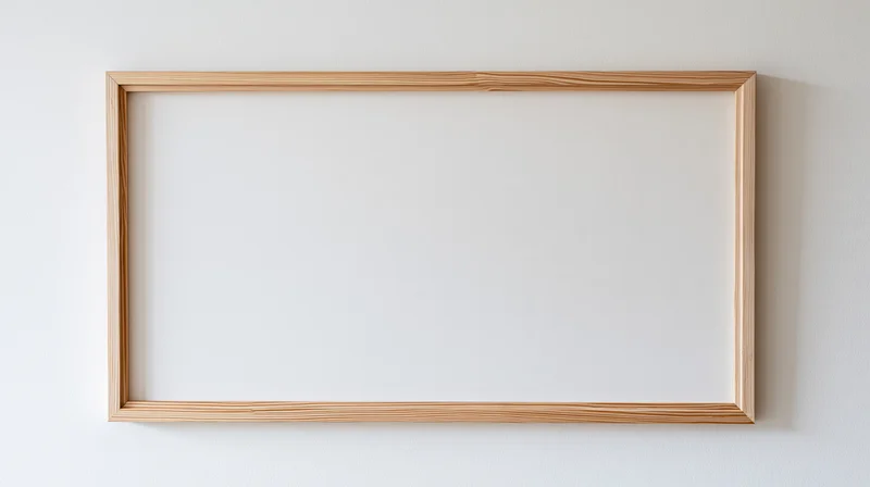 Thin natural wood picture frame hanging on plain white wall