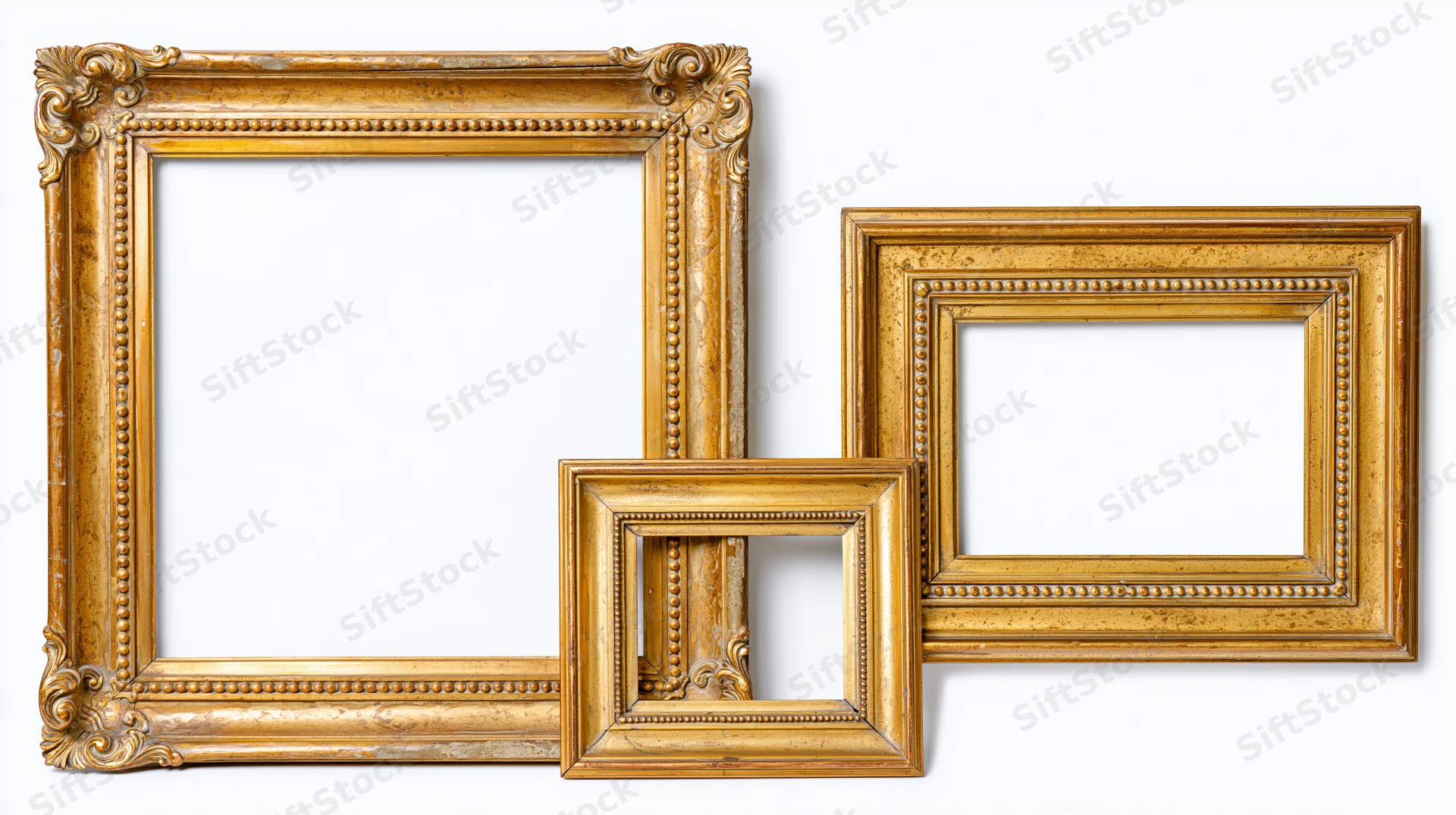 Three ornate gilded picture frames arranged against a plain white background