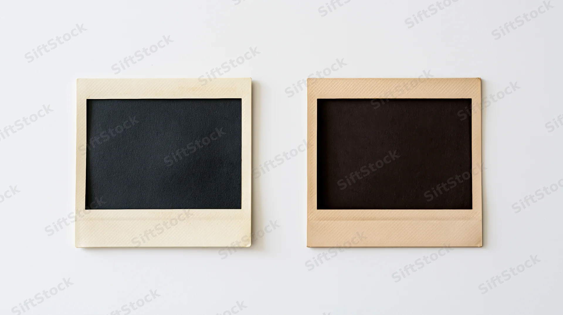 Two blank instant film photo prints lying flat side by side on white surface