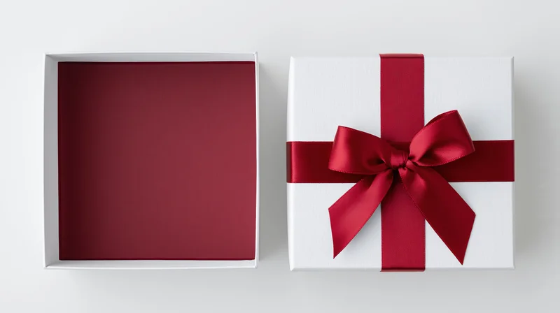 Two white gift boxes one open and one closed with red ribbon bow on plain surface