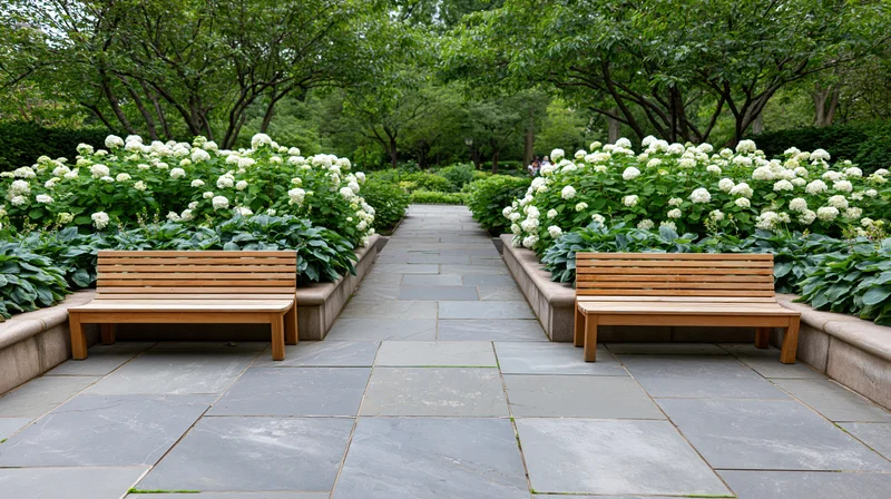 Two wooden benches flanking a wide flagstone pathway in a garden setting