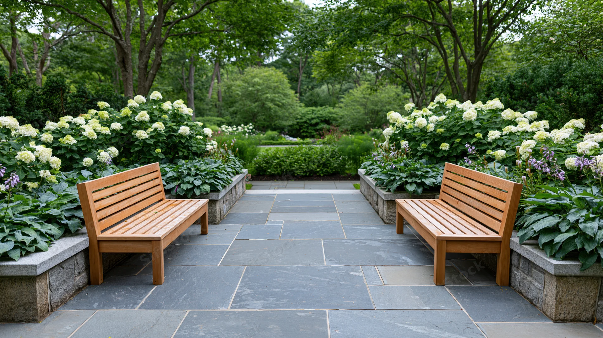 Two wooden benches flanking a flagstone path in a garden setting