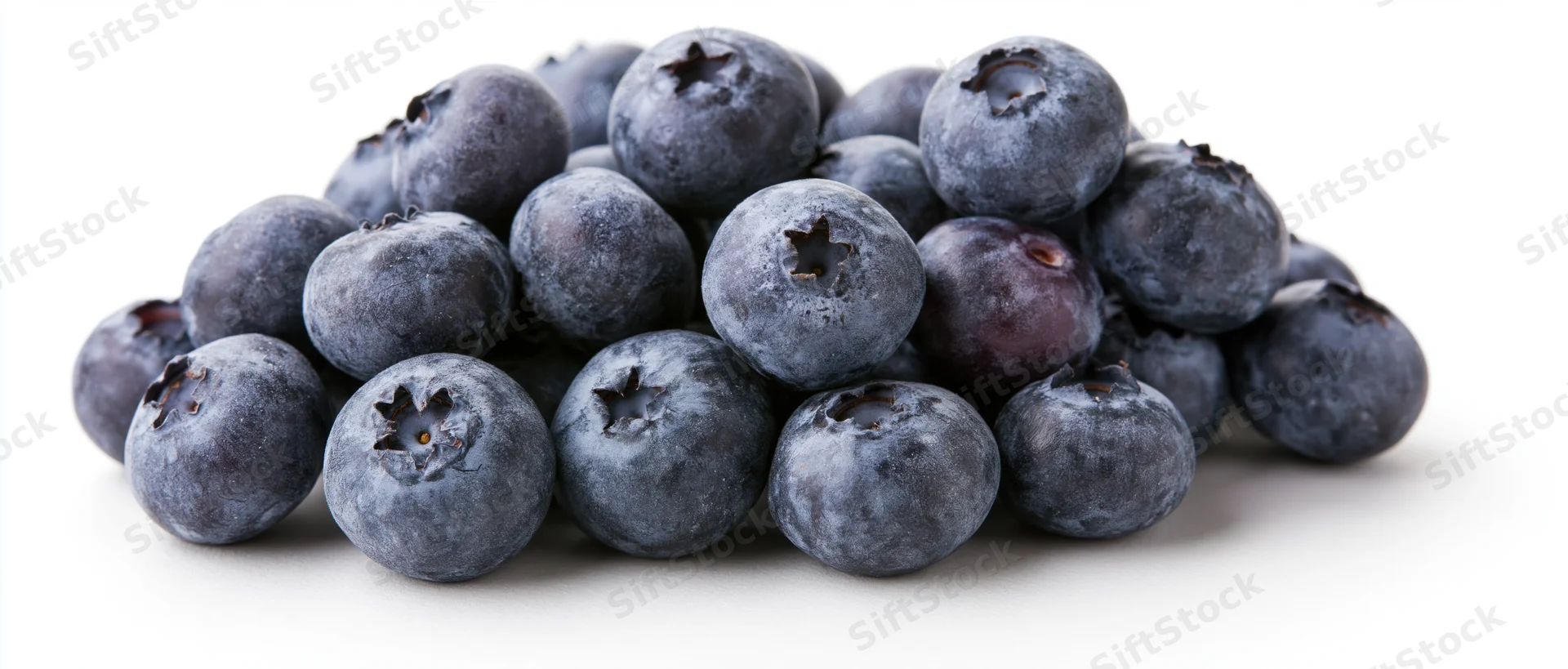 A pile of fresh blueberries arranged in a low mound on a white surface