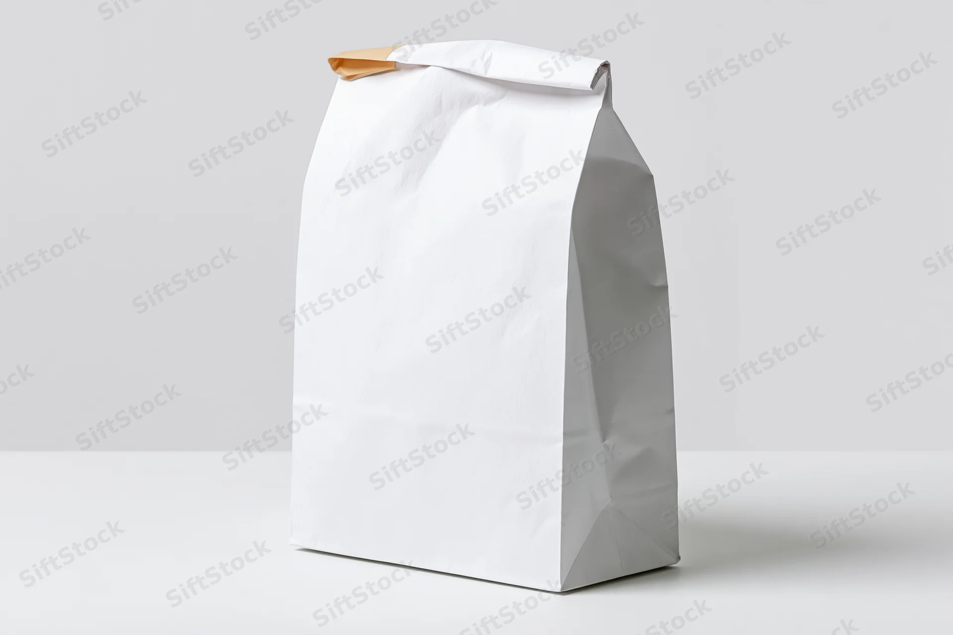 White paper bag standing upright on a white surface with copyspace for branding