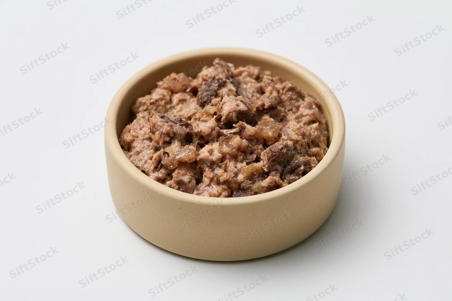 Chunky wet cat food in a small beige ceramic bowl on white background