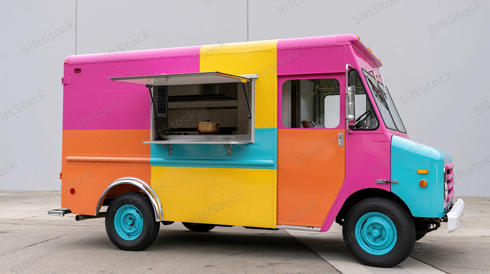 Vintage step-van food truck with open service window and colorful paint scheme parked on concrete