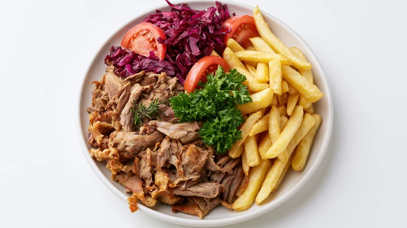 Shredded meat with fries and red cabbage on a white plate