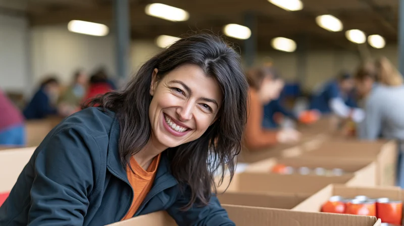 Woman smiling while sorting canned food in a warehouse with volunteers around her