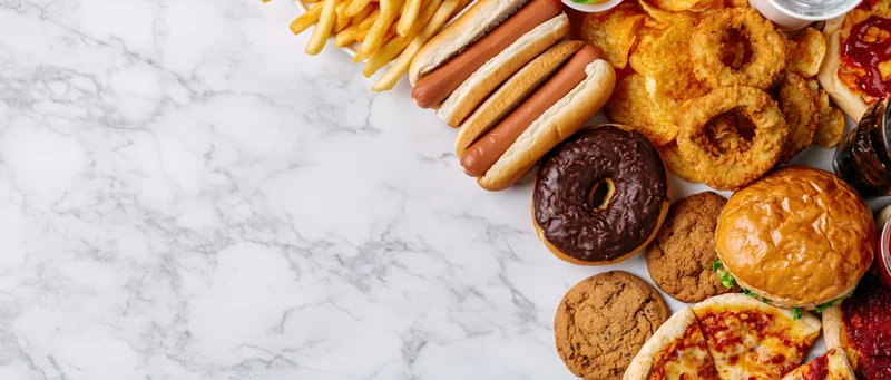 Assorted fast food items arranged on a marble countertop with copyspace on the left