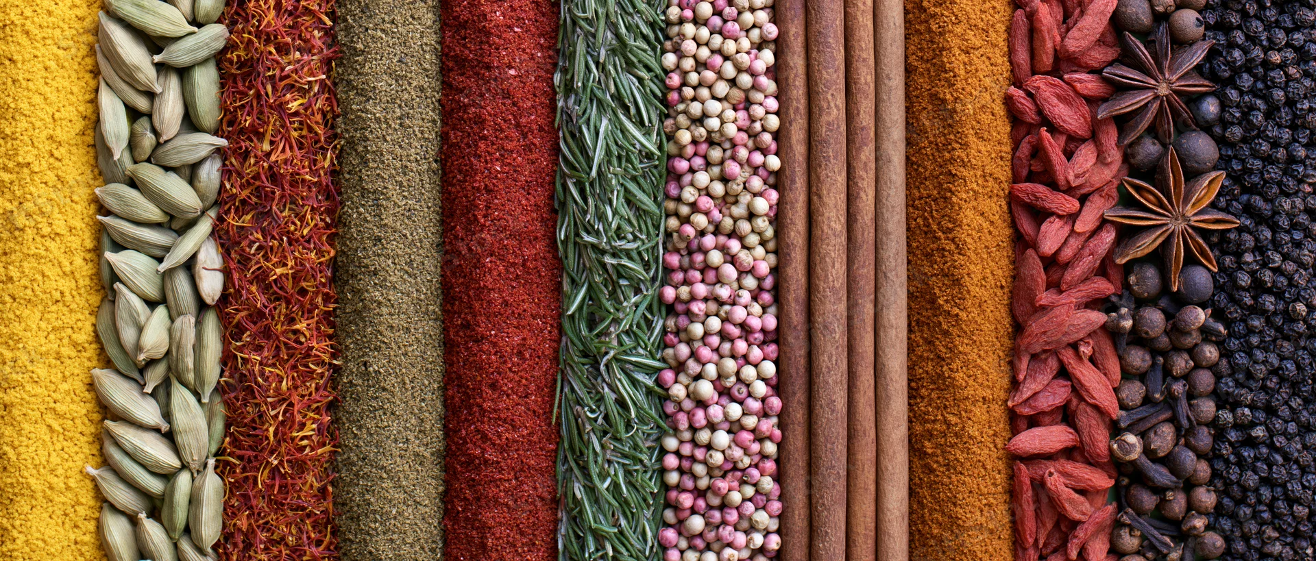 Vertical arrangement of whole and ground spices in colorful rows, flat lay view