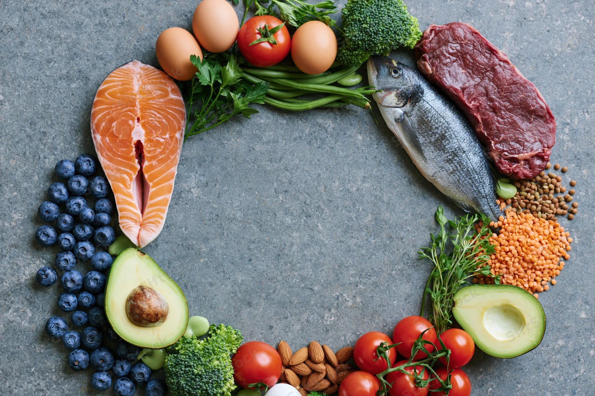 Whole foods arranged in a circular frame on a slate surface