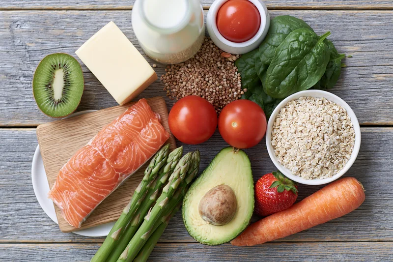 Assorted whole foods arranged in flat lay on wooden table