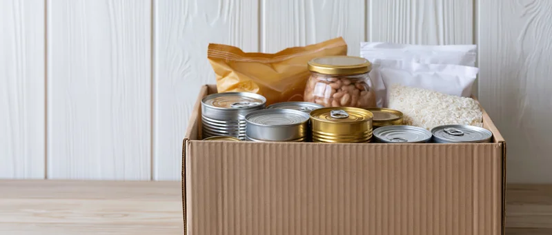 Cardboard box filled with canned goods and dry food staples for donation