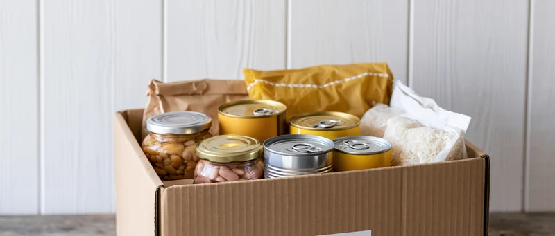 Cardboard box filled with canned goods and dry food staples for donation