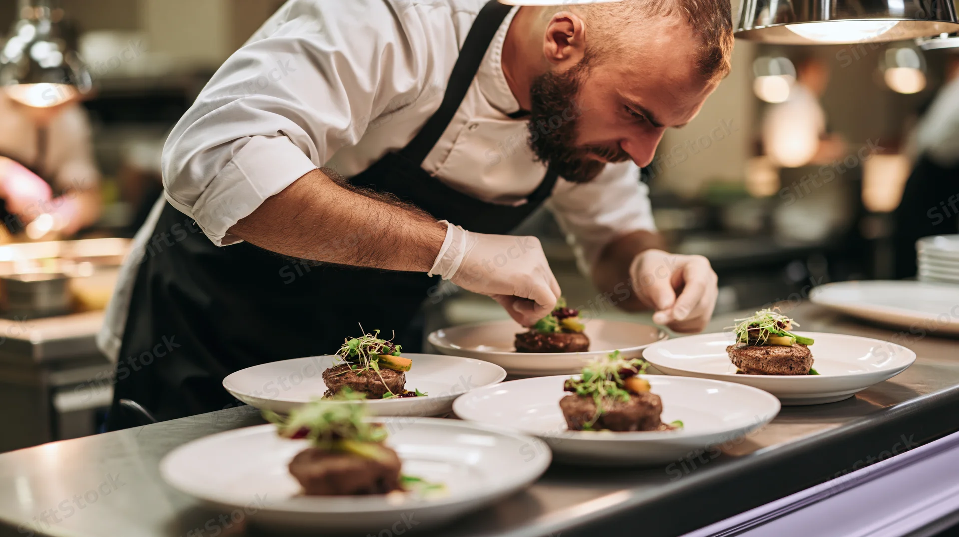 Chef plating gourmet dishes in a professional kitchen