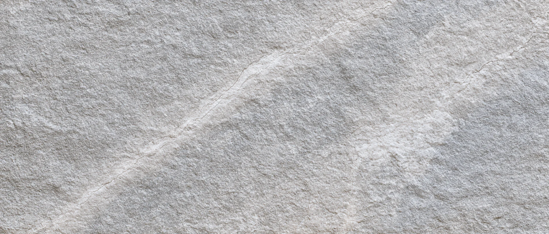 Close-up of natural grey stone surface with visible texture and veins filling the frame