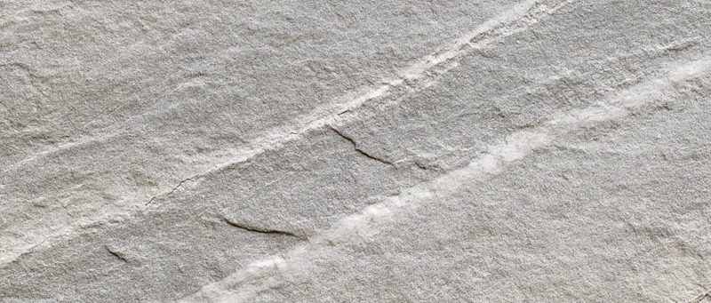 Close-up of natural grey stone surface with visible cracks and veins