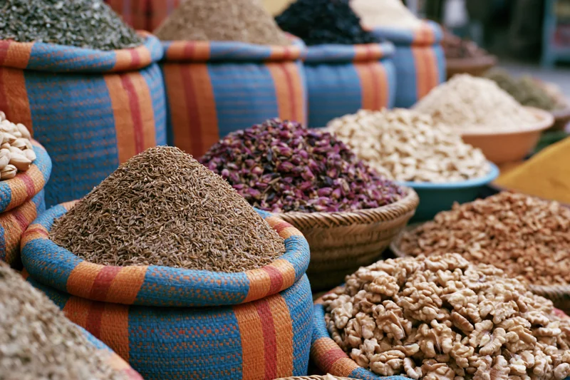 Colorful woven baskets and bowls filled with dried spices arranged in a market display