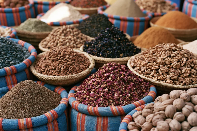 Colorful woven baskets filled with dried spices and nuts arranged in a market display
