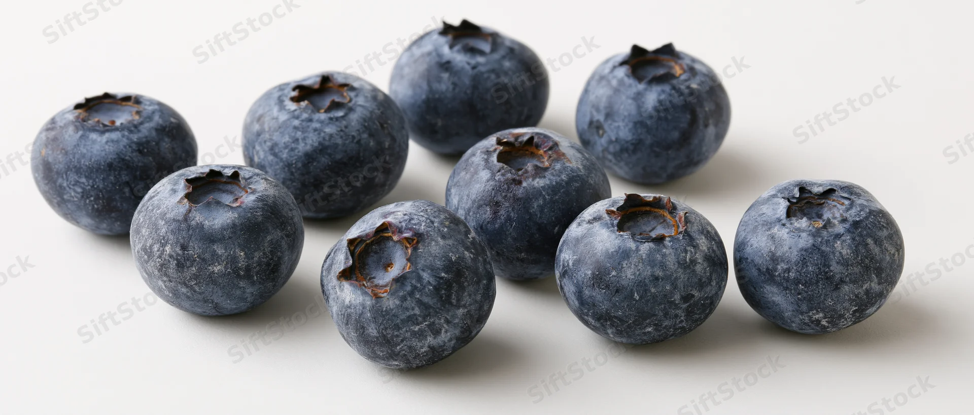 Fresh blueberries scattered on a white surface