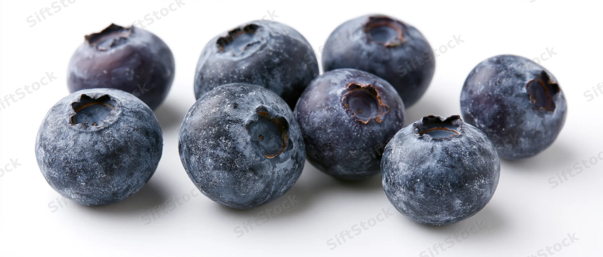 Fresh blueberries scattered on a white surface